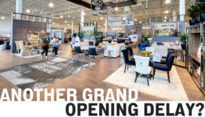 Store entrance with text reading Another Grand Opening Delay?